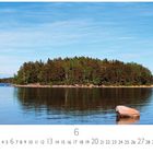 "Insel auf der Seenplatte". Kalender mit Juni-Daten. Eine bewaldete Insel spiegelt sich in ruhigem Wasser unter blauem Himmel.