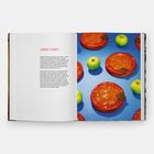 "Apple Tarts" steht in großen roten Buchstaben auf der linken Buchseite. Rechts sind mehrere Apfeltartes und grüne Äpfel zu sehen.