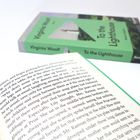 Ein aufgeschlagenes Buch, nebenbei ein geschlossenes Buch mit dem Titel "To the Lighthouse" von Virginia Woolf, Reclam-Verlag.