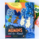 "Die Mumins und der Komet" steht in großen Buchstaben auf dem Cover mit fröhlichen Figuren und bunten Bäumen.