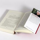 Ein geöffnetes Buch mit dem Kapitel "NEUSTART". Ein Lesezeichen beschreibt PETRA MORSBACH, zeigt ihr Foto und ihre Biografie.