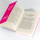 Auf einer magentafarbenen Seite steht: „'Was wollt ihr Frauen denn noch alles?' Einfache Antwort: Alles!“. Das Buch ist offen.