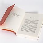 „Armut und Geburt“ steht oben auf einer Buchseite. Ein aufgeschlagenes Buch liegt auf einer weißen Oberfläche.