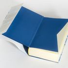 Text auf farbigem Papier, in einem geöffneten Buchumschlag. Das Buch selbst hat einen schlichten, blauen Einband.