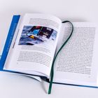 Ein Buch liegt offen. Auf der linken Seite ein Foto eines Rennbootes auf dem Meer mit der Aufschrift "WIN" auf dem Segel. Ein grünes Leseband liegt über den Seiten.