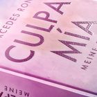 Text: "Mercedes Ron", "Culpa Mía", "Meine Schuld". Der Hintergrund ist in einem zarten Rosa-Lila-Ton gehalten.
