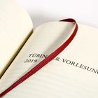 Es steht "Tübinger Vorlesungen 2019" auf einer Buchseite, markiert mit einem roten Leseband.