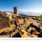 Kalender mit Monat Juni. Zwei Radfahrer auf einem steinigen Pfad vor einer alten, steinernen Burg und Bergkulisse.
