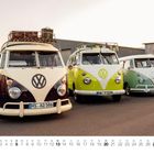 „Revivalfreunde“ auf einem Gebäudeschild, drei VW-Busse in verschiedenen Farben parken nebeneinander, Kalender für Juni.