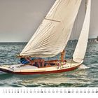 "6" und "PIRAT IV". Ein klassisches Segelboot auf einem See, im Hintergrund Bäume an der Küste.