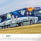 Juni 2027. Ein dekorierter LKW mit Weltraummotiven wie Astronauten und Planeten auf der Seite, steht auf einer Wiese.