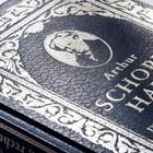 Buchcover aus Leder mit silbernem Text: "Arthur Schopenhauer". Ornamente umrahmen ein stilisiertes Porträt.