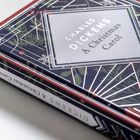 „Charles Dickens: A Christmas Carol“ auf einem Buchcover mit festlichen Designs in Rot und Grün.