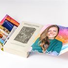 Texte beschreiben ein Klassentreffen, Buch: REMEMBER. Foto einer lächelnden Frau. Bunte Landschaftsaufnahmen.