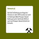 „Antwort a): Seit Schließung von Auguste-Victoria 2015 wurde nur noch in Prosper-Haniel Kohle produziert. Ende 2018 auch dort Schluss.“ Unten sind gekreuzte Hämmer als Symbol auf grünem Hintergrund.