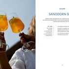 "Sanddorn Spritz" Rezept: Bio-Orange, Eiswürfel, Sanddornlikör, Prosecco, Sprudelwasser, Minze. Zwei Gläser stoßen an.