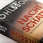 "NACHT SCHATTEN" in roten Buchstaben, "Ein SCHWEDENKRIMI mit AUGUST STRENG". Buchcover mit dunkler Landschaft.