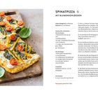 SPINATPIZZA MIT BLUMENKOHLBODEN. Bild einer rechteckigen Pizza mit Kirschtomaten, Spinat und Paprika auf Holzbrett.