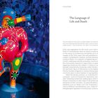 Ursula Bode: The Language of Life and Death; Zitat von Paul Scheerbart über brillant leuchtende Farben. 

Bunt gemusterte Skulptur in blauer Umgebung.