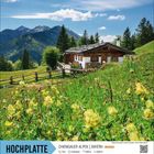 "Hochplatte, Chiemgauer Alpen, Bayern. Mai bis Oktober. Almhütte vor Bergkulisse und grüner Wiese, gelbe Blumen im Vordergrund."