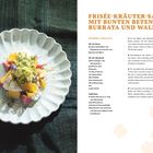 Frisée-Kräuter-Salat mit bunten Beten, Burrata und Walnüssen. Links Teller mit farbenfrohem Salat auf dunklem Tuch.