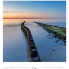 06, Sonntag. Buhnen am Strand der Nordsee. Im Hintergrund: ruhiges Meer, heller Himmel bei Sonnenaufgang.