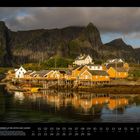 06 Fischerdorf auf der Lofoten-Insel Sakrisøy. Häuser auf Stelzen im Wasser, umgeben von steilen Bergen und ruhiger See.