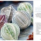 Papierornamente mit gestempelten Christbaumkugeln, bunte gefaltete Kugeln mit verschiedenen Mustern und Texturen.