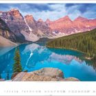 Moraine Lake, Banff Nationalpark, Alberta. Ein leuchtend blauer See mit Bergen im Hintergrund und dichtem Wald am rechten Ufer.