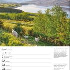 Juni, 25. Woche. Sommeranfang 21.6. Schafe auf einer grünen Wiese, im Hintergrund Berge und ein See.