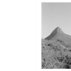 Der Text „La montagne était leur secret“ steht links. Rechts ein schwarz-weiß Foto eines Berges mit karger Vegetation.