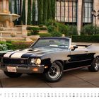 JUNI-Kalender mit einem schwarzen 1972er Buick GS 455 Cabriolet vor einem eleganten Brunnen und Garten.