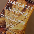 Text auf dem Cover: "Margaret Laurence Roman Glücklichere Tage". Hintergrund: ein Herbstblatt in Brauntönen.