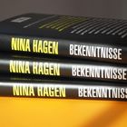 Drei schwarze Buchrücken mit der Aufschrift "NINA HAGEN BEKENNTNISSE". Links oben steht "bene!" in kleinerer Schrift.