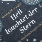 Text: "Rainer Haak, Hell leuchtet der Stern, 24 Weihnachtsgeschichten." Verzierte dunkle Oberfläche mit Sternen.
