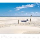 "Juni 2027 | Am Meer." Eine Hängematte zwischen zwei Pfählen auf einem verlassenen Sandstrand unter blauem Himmel.