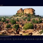 04 April, Kalender mit Dorf in Westafrika; traditionelle Hütten vor einem großen, felsigen Hügel.