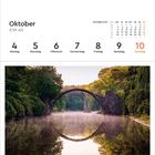 Oktober, KW 40, Montag 4 bis Sonntag 10. Foto: Steinbrücke über ruhigem Wasser, bewaldete Umgebung, Nebel steigt auf.