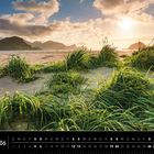 "Lofoten 06" und "Hauklandstranda, Vestvågøy". Sandige Dünen mit Grasbüscheln, im Hintergrund Berge bei Sonnenuntergang.
