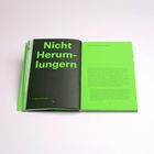 Links: "Nicht Herumlungern" in großer, grüner Schrift auf dunklem Hintergrund. Rechts: Englischer Text auf hellgrünem Hintergrund.