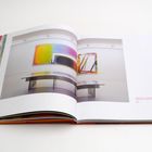 Text: "LOOK INTO THE SUN WITH YOUR EYES CLOSED 02, 2022." Offenes Buch mit moderner Kunstgalerie-Abbildung.