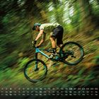 Kalender mit Datum in einer Reihe unten, "6" rechts. Biker in Bewegung, Wald im Hintergrund, dynamische Unschärfe.