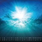 Kalender mit Daten und Wochentagen, unter Wasser, Sonnenstrahlen durchdringen die blaue Wasseroberfläche.