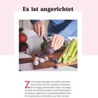 "Es ist angerichtet" in großer Schrift. Jemand schneidet eine rote Knolle auf einem Brett, umgeben von Blaubeeren und Sellerie.