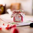 Etikett mit der Aufschrift "mit Liebe gemacht!", Marmeladenglas mit floralem Stoffdeckel.