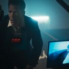 Ein Mann in einem Anzug blickt besorgt in eine Kamera. Ein Bildschirm zeigt ein Nahaufnahme seines Gesichts. Eine rote Anzeige zeigt „09:51:18“.