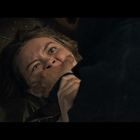 Eine Frau liegt auf dem Boden, ihr Gesicht zeigt Angst. Eine Hand hält ihren Mund fest zu, ein Messer ist nah.