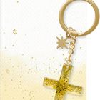 "Dein Wegbegleiter" steht oben. Darunter ein goldener Kreuz-Schlüsselanhänger mit glitzernden Details und einem kleinen Stern.