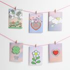 Oben: "Good luck." Verschiedene Karten mit Illustrationen von Wolken, Blumen und Herzen an rosafarbenen Fäden.