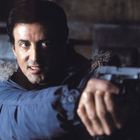 Ein Mann in einer Winterjacke zielt konzentriert mit einer Pistole nach vorn. Sein Gesichtsausdruck ist angespannt.